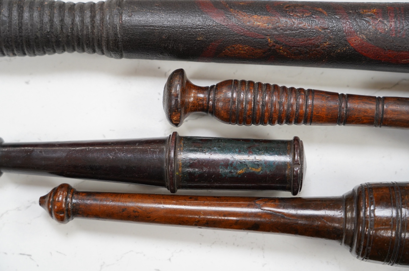 A large fruitwood gavel, a truncheon, a lead-weighted cosh and two others, longest 42cm. Condition - fair